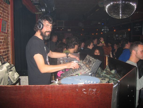 photo of DJ smiling at the camera in a dance club